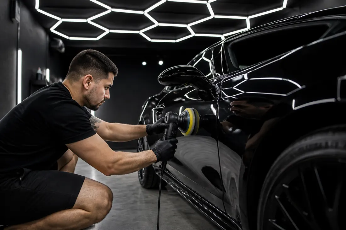 Kaio polindo a lateral de um esportivo preto sob a luz de LED