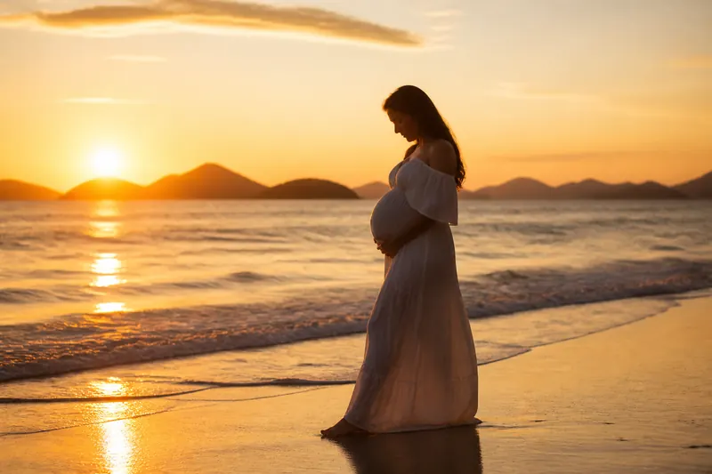Gestante na praia ao pôr do sol