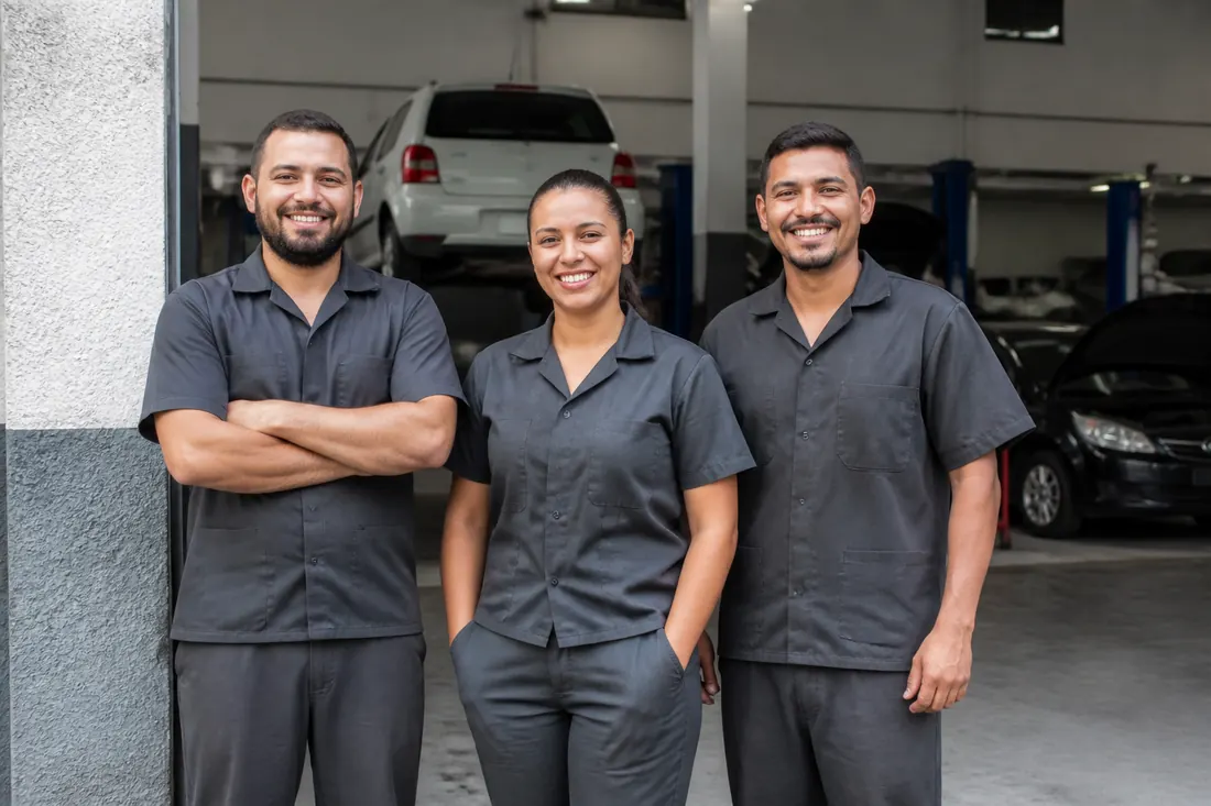 Equipe de mecânicos na entrada da oficina